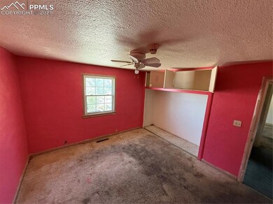Unfurnished bedroom with a textured ceiling, carpet, and ceiling fan