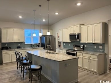 Kitchen with stainless steel appliances, light woo