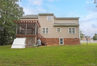 Rear view of property featuring a lawn, a pergola,
