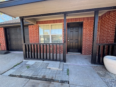 Entrance to property featuring a porch and brick siding
