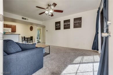 Carpeted living area featuring ceiling fan and goo