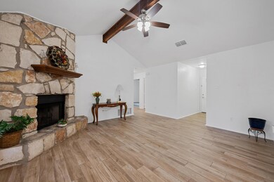Living area featuring ceiling fan, light wood-sty