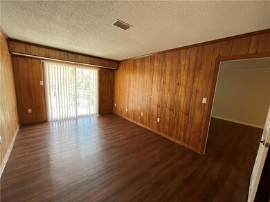 Unfurnished room with a textured ceiling, dark har
