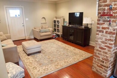 Living area with hardwood floors and exposed brick