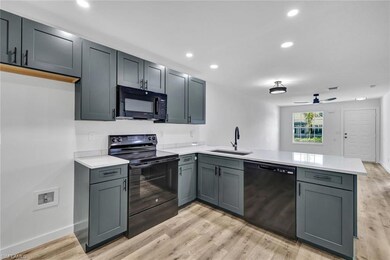 Kitchen featuring black appliances, a peninsula, l