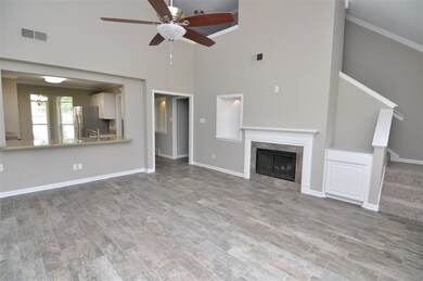 The great room showcases vaulted ceilings with fan