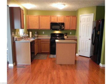 The kitchen features maple cabinets, oak hardwood 