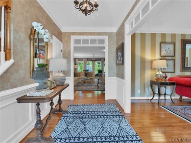 Entryway featuring wood-type flooring, a chandelie
