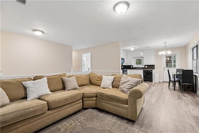 Living room featuring wine cooler, light wood fini