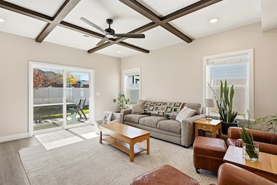 Living room featuring ceiling fan, wood finished floors, recessed lighting, beamed ceiling, and coffered ceiling