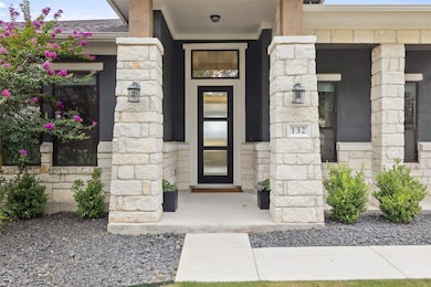 Doorway to property with stone siding and a porch