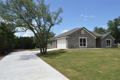 View of front of property featuring driveway, bri