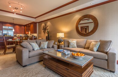 The open-concept great room offers generous seating throughout the living area, seamlessly extending to the adjacent lanai—perfect for relaxing, entertaining, or enjoying the island breeze