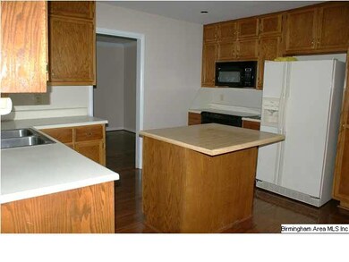 Kitchen has island with breakfast bar, built-in ra