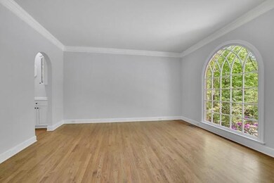 Empty room with light wood-type flooring, crown molding, and baseboards