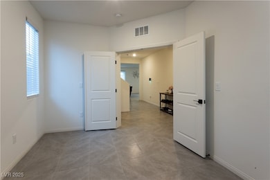 Empty room with a smoke detector, baseboards, and