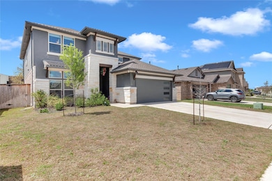 Prairie-style home featuring stone siding, drivew
