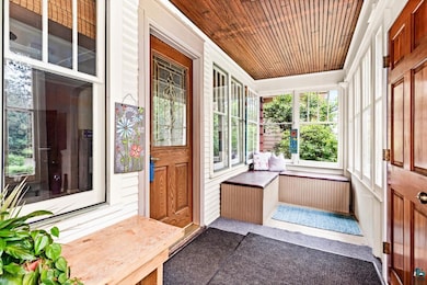 Unfurnished sunroom with wooden ceiling and ornamental molding