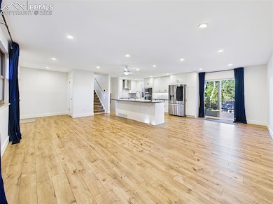 Large open-plan space with natural light, recessed lighting, and direct access to the outdoor deck through sliding glass doors.