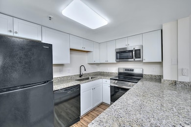 Kitchen featuring white cabinets, a sink, and blac