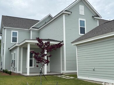 Back of property featuring a lawn and a shingled roof