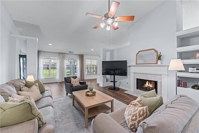 Living area featuring ceiling fan, wood finished f