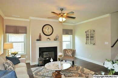 The living showcases a natural gas fireplace, crown molding, and hand scraped hardwood flooring.