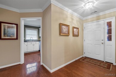 Hardwood floors and kitchen to the right of the en