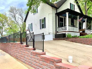 Extensive retaining wall with wrought iron fence and brand new concrete garage