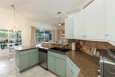 Kitchen with dishwasher, a peninsula, blue painted wood cabinetry, backsplash, and ceiling fan