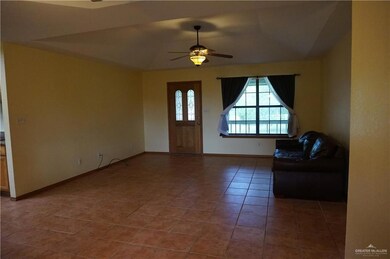 Unfurnished living room featuring tile patterned flooring, lofted ceiling, and ceiling fan