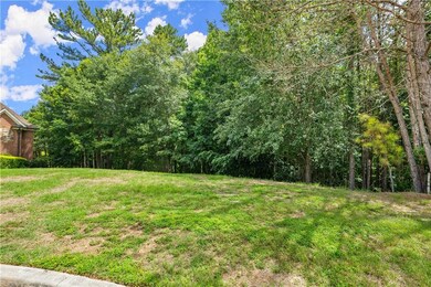 View of green lawn featuring a view of trees