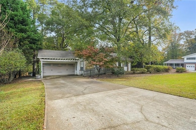View of front of home featuring a front lawn, driveway, and an attached garage