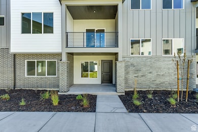 Entrance to property featuring board and batten siding and brick siding