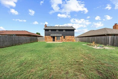 Rear view of house featuring stone siding and a chimney