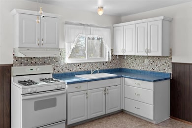 White Kitchen cabinets, gas range, window over Kit