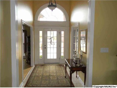 FOYER FEATURES LIMESTONE TILE FLOORS, 15 FOOT SMOOTH CEILINGS, CROWN MOLDING