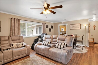 Living room featuring crown molding, light hardwoo