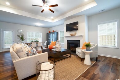 Living room featuring visible vents, ceiling fan, 