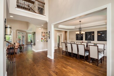 Foyer view as you walk in the front door. All hardwood floors downstairs. Rod iron spindles on balcony.  