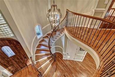 Dramatic 2-story foyer with wrought iron curved st
