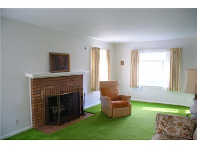 Living Room. Carpet in front right corner easily pulls back to expose the hardwood floors - south and west windows flood this living room with natural light.