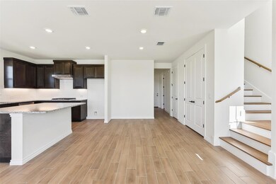 Kitchen with light wood finished floors, visible 