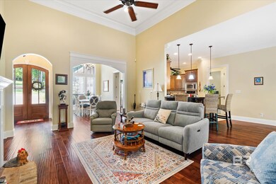 Living room with ceiling fan, ornamental molding, french doors, dark hardwood / wood-style floors, and a towering ceiling