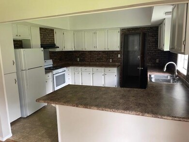 Kitchen featuring sink, kitchen peninsula, white a