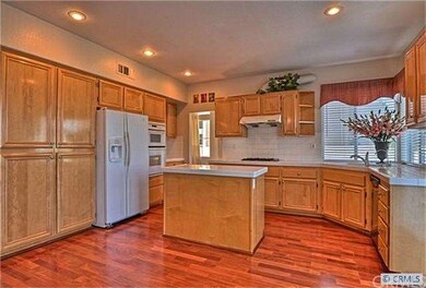 Sparkling kitchen features rich maple cabinetry, t