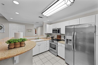 Kitchen featuring appliances with stainless steel finishes, ornamental molding, light tile patterned floors, white cabinets, and recessed lighting