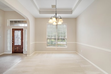 Another view of the large dining room with unique ceiling detail and lots of space.