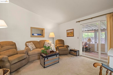 Living area with carpet floors and lofted ceiling