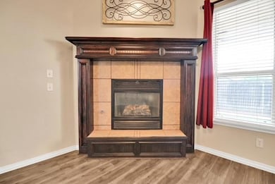 Detailed view of wood finished floors, baseboards, and a fireplace